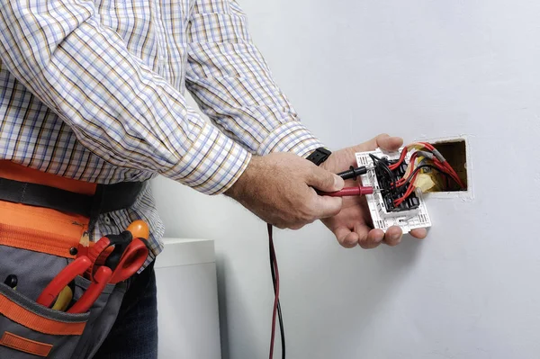 Electrician repairing outlet