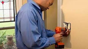 Man working on wall switch